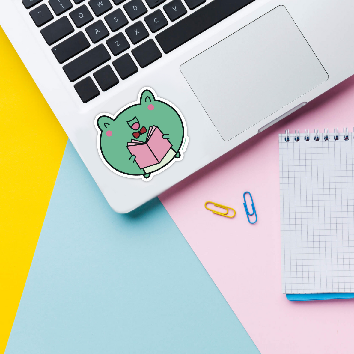 frog reading sticker on laptop