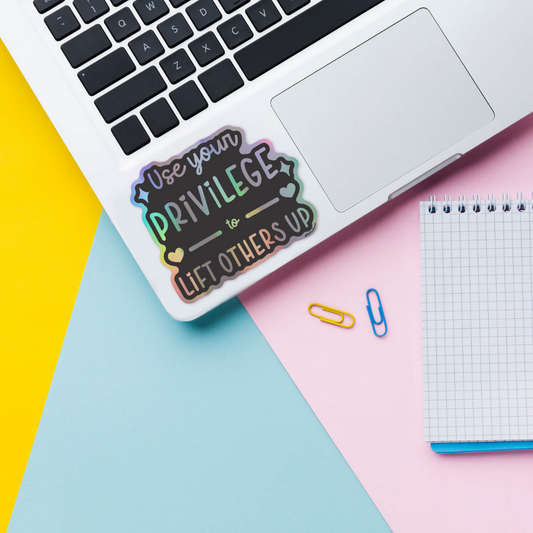 lift others holographic sticker on laptop