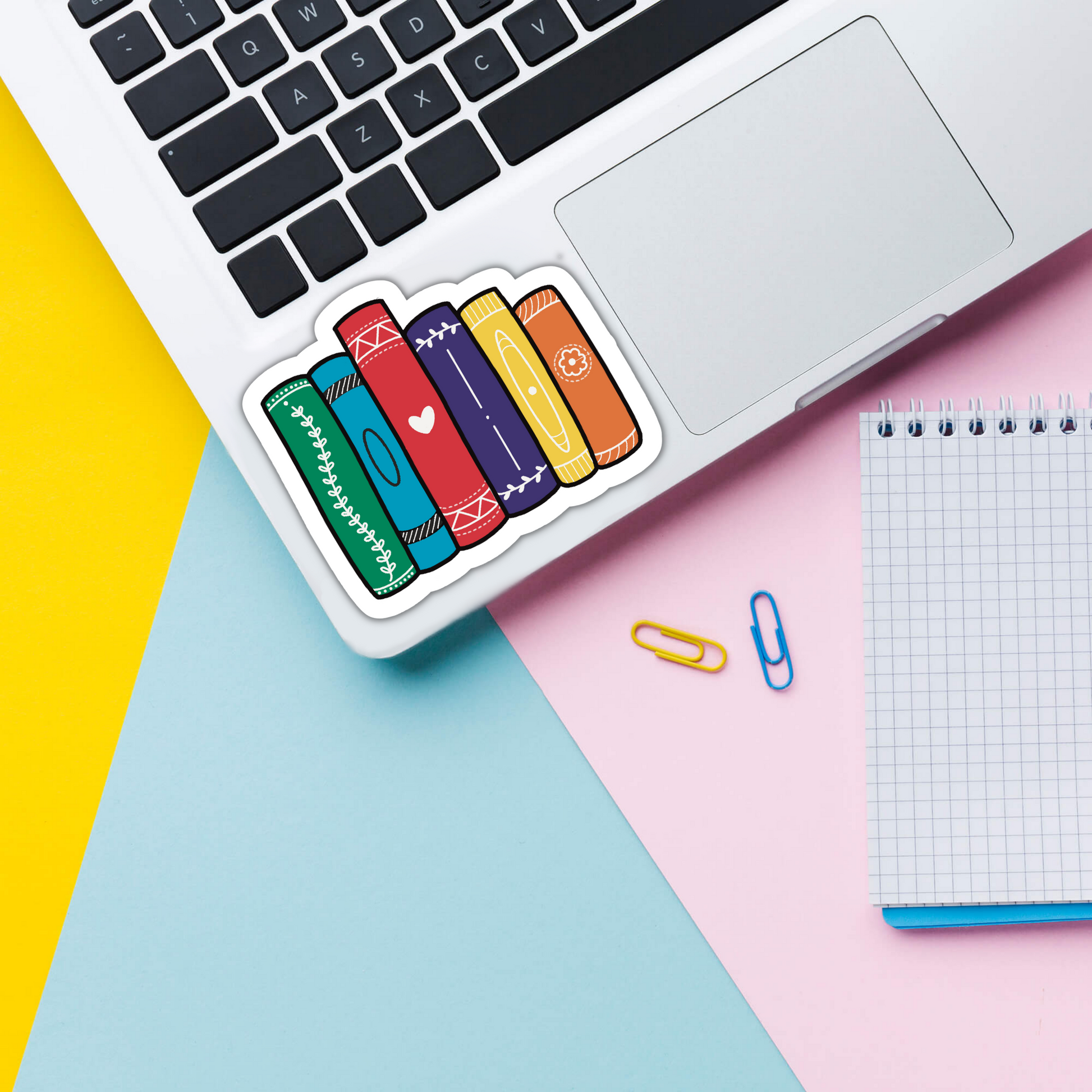 Pride book stack vinyl sticker on laptop