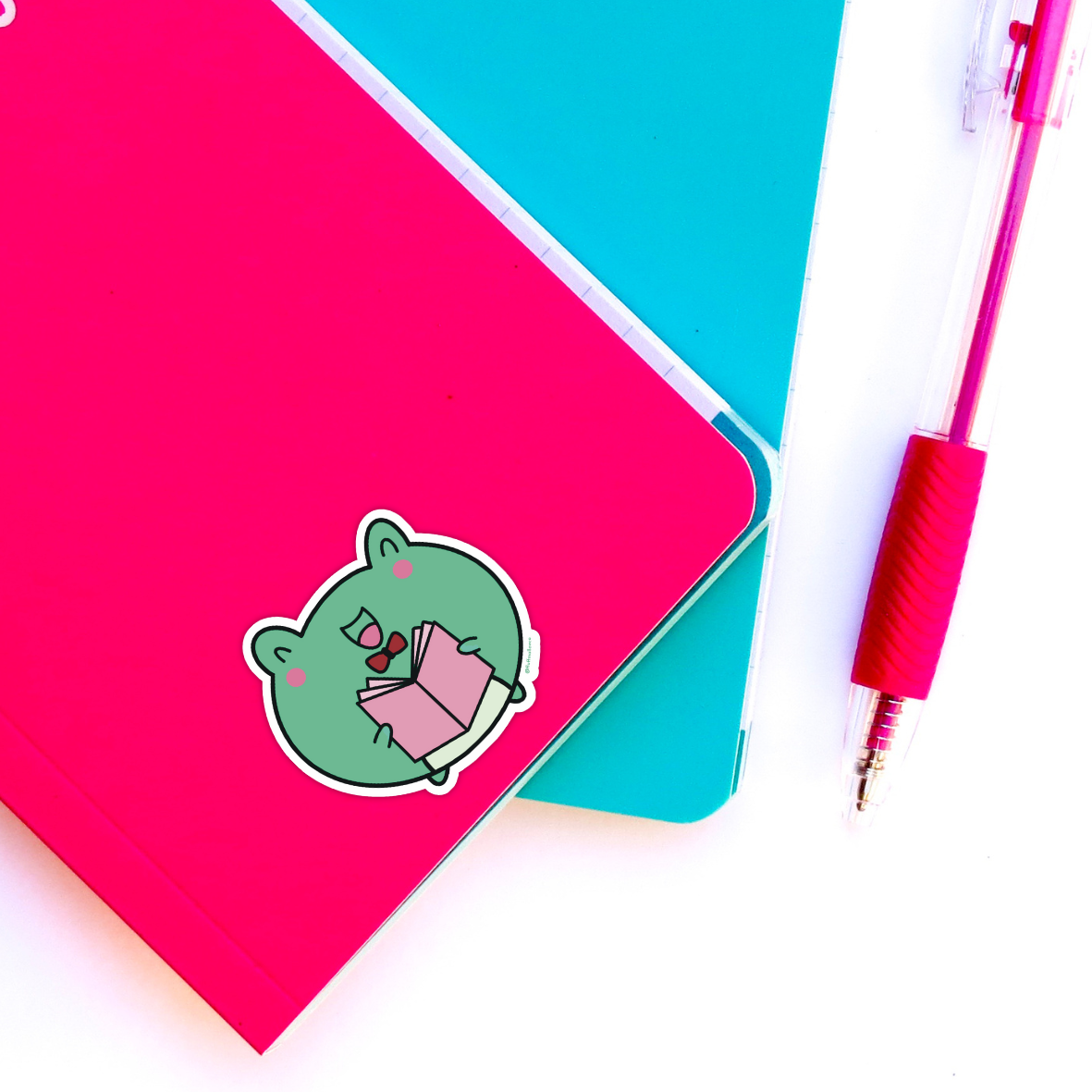 frog reading sticker on notebook 